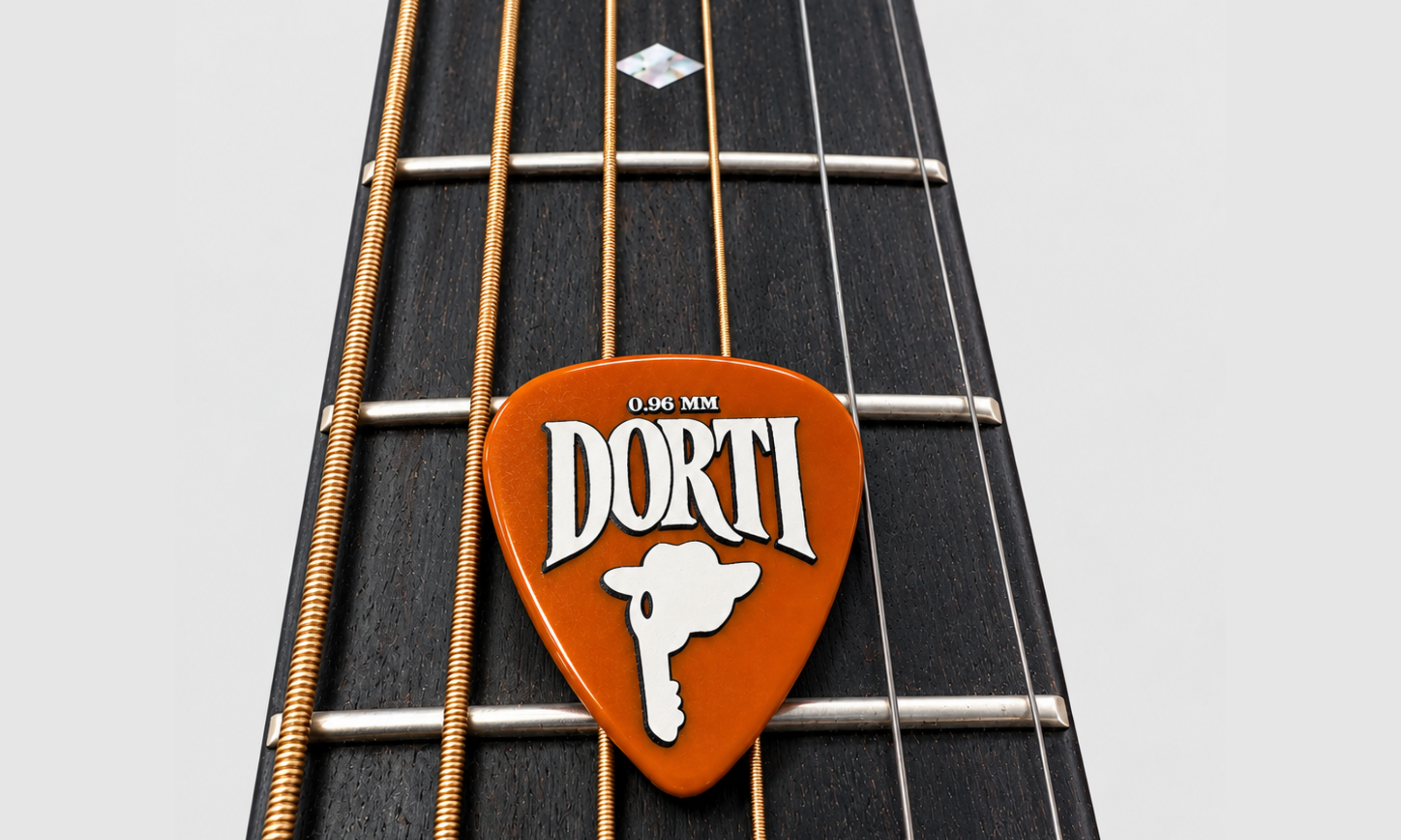 DORTI Standards nylon guitar pick on an acoustic guitar neck, close-up