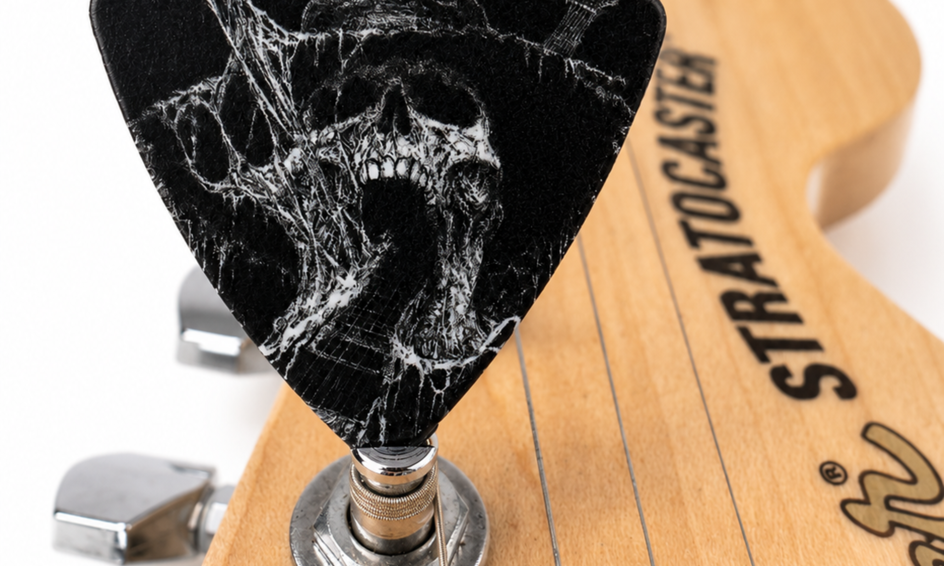 DORTI Neck Feeder guitar pick on the headstock of a Stratocaster