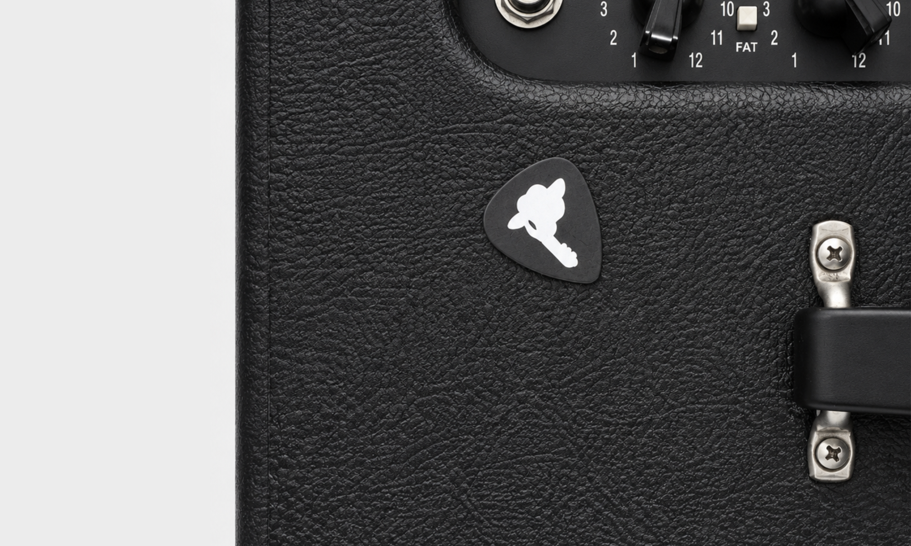 DORTI Jimi Skull logo guitar pick on the front of a black guitar amplifier