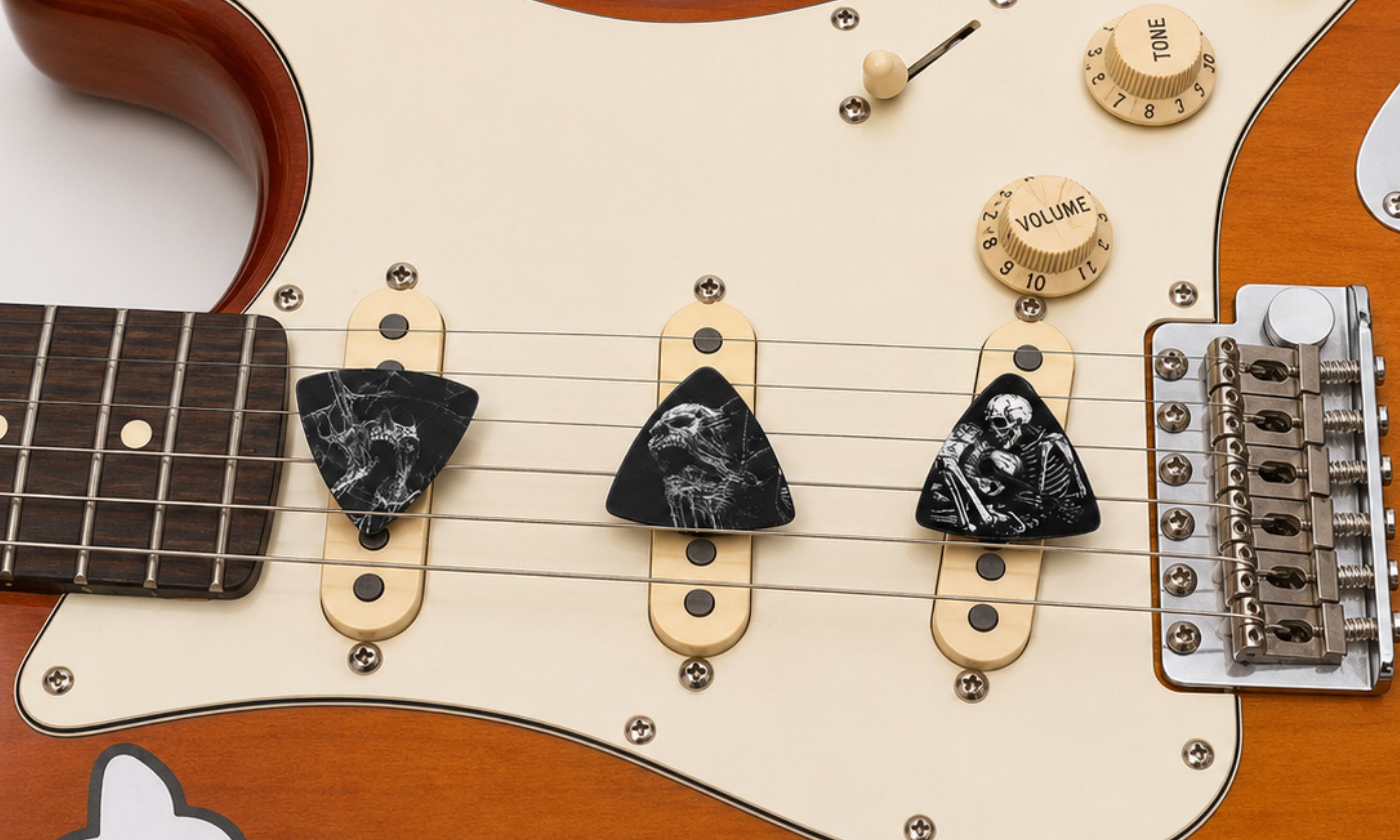 DORTI Boneyard variety pack picks on the pickups of a Stratocaster-style guitar