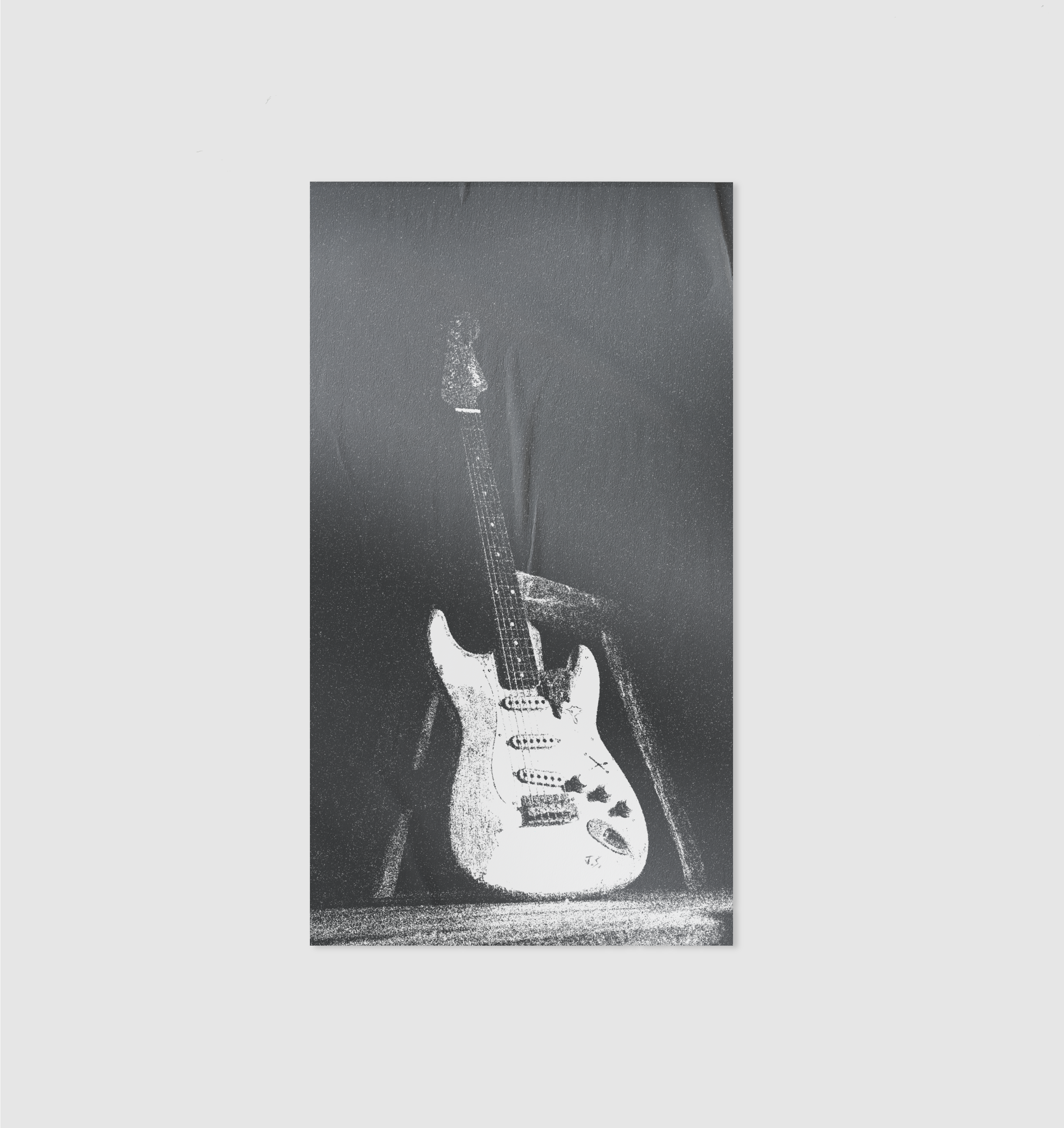 Black and white electric guitar on a stand against a dark background