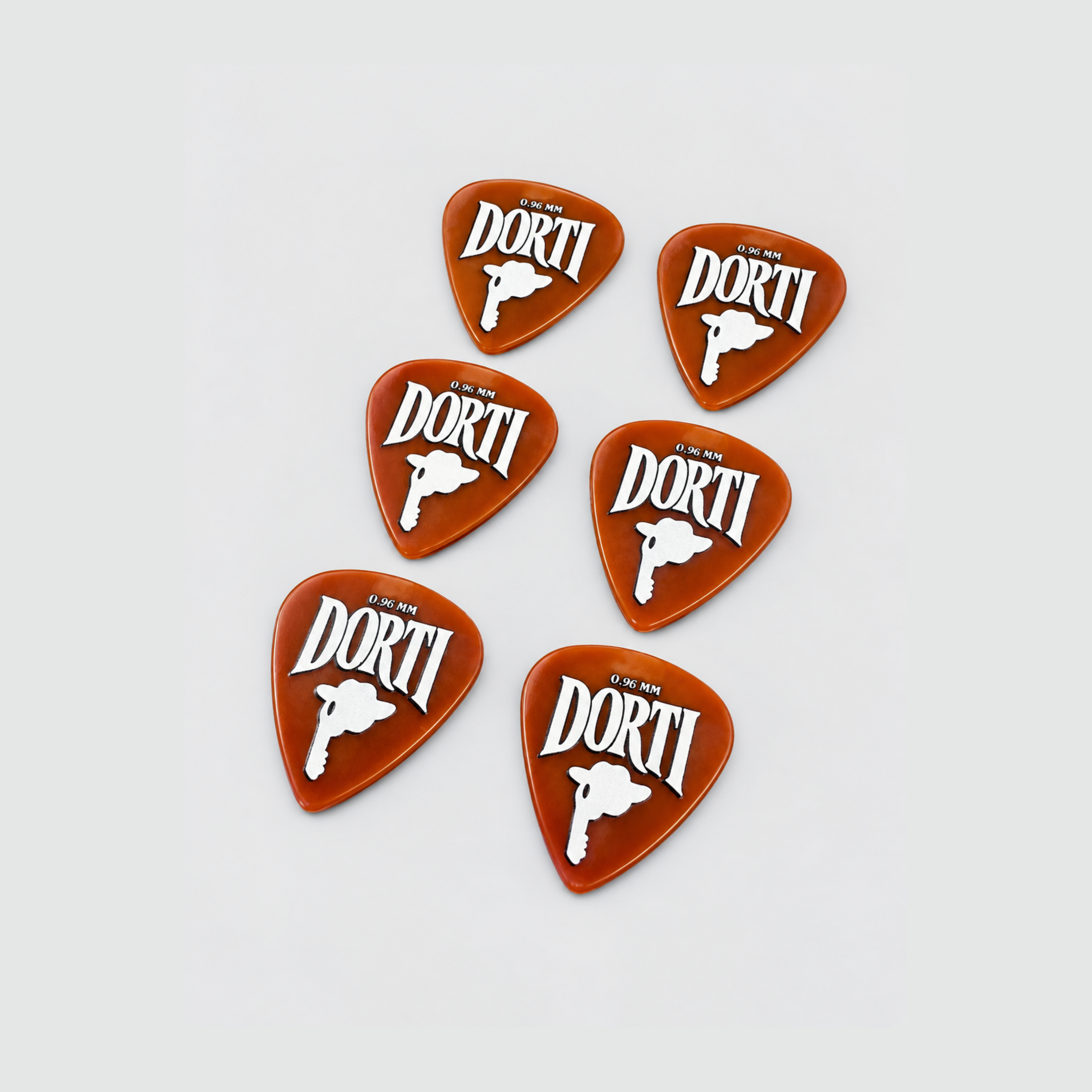 Six DORTI orange nylon guitar picks, 0.96mm, scattered on a light grey background
