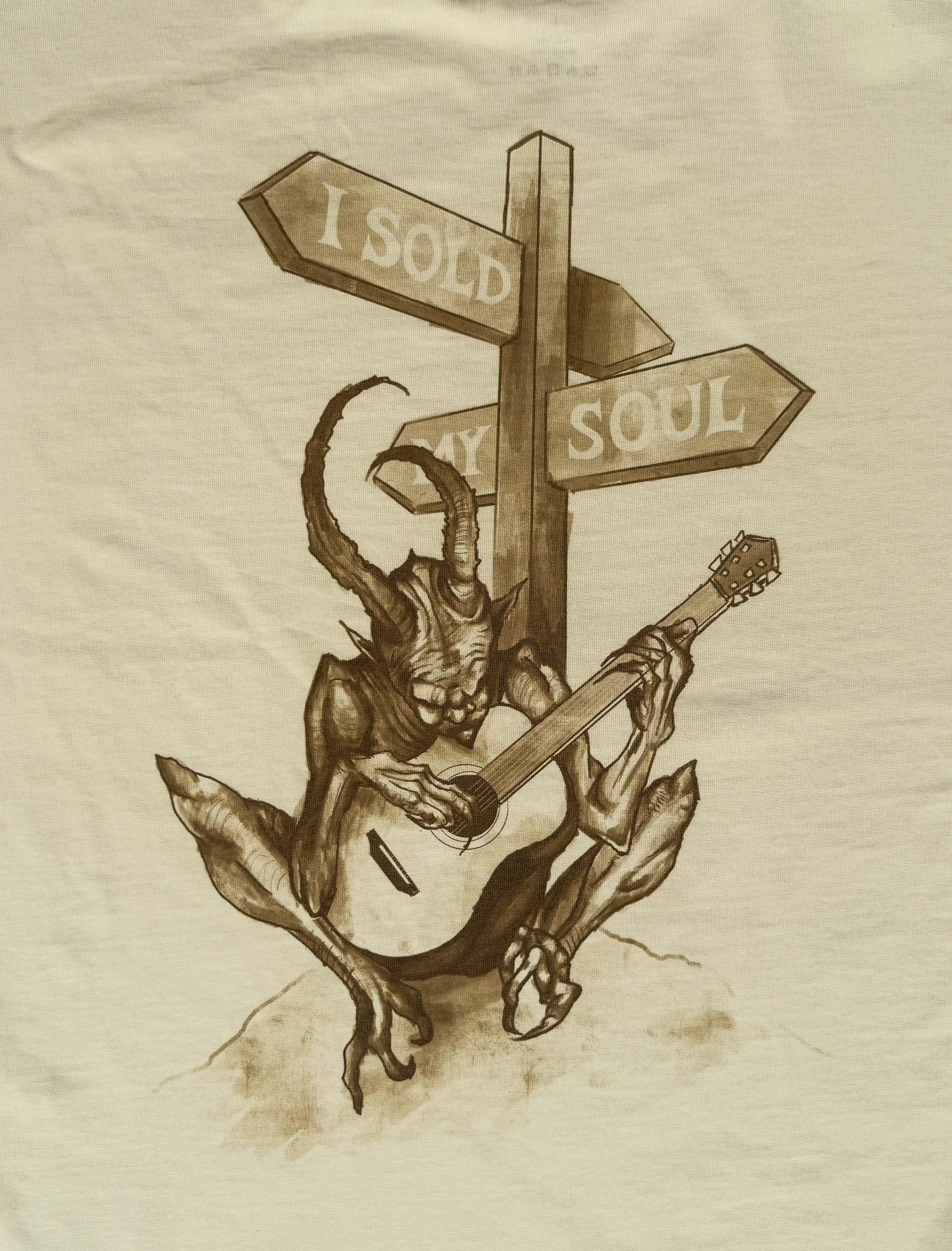 Illustration of a demon-like creature playing a guitar with 'I Sold My Soul' signpost on beige background. DORTI T-Shirt.