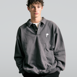 Man wearing a gray DORTI sweater with a small Jimi Skull logo on a plain background