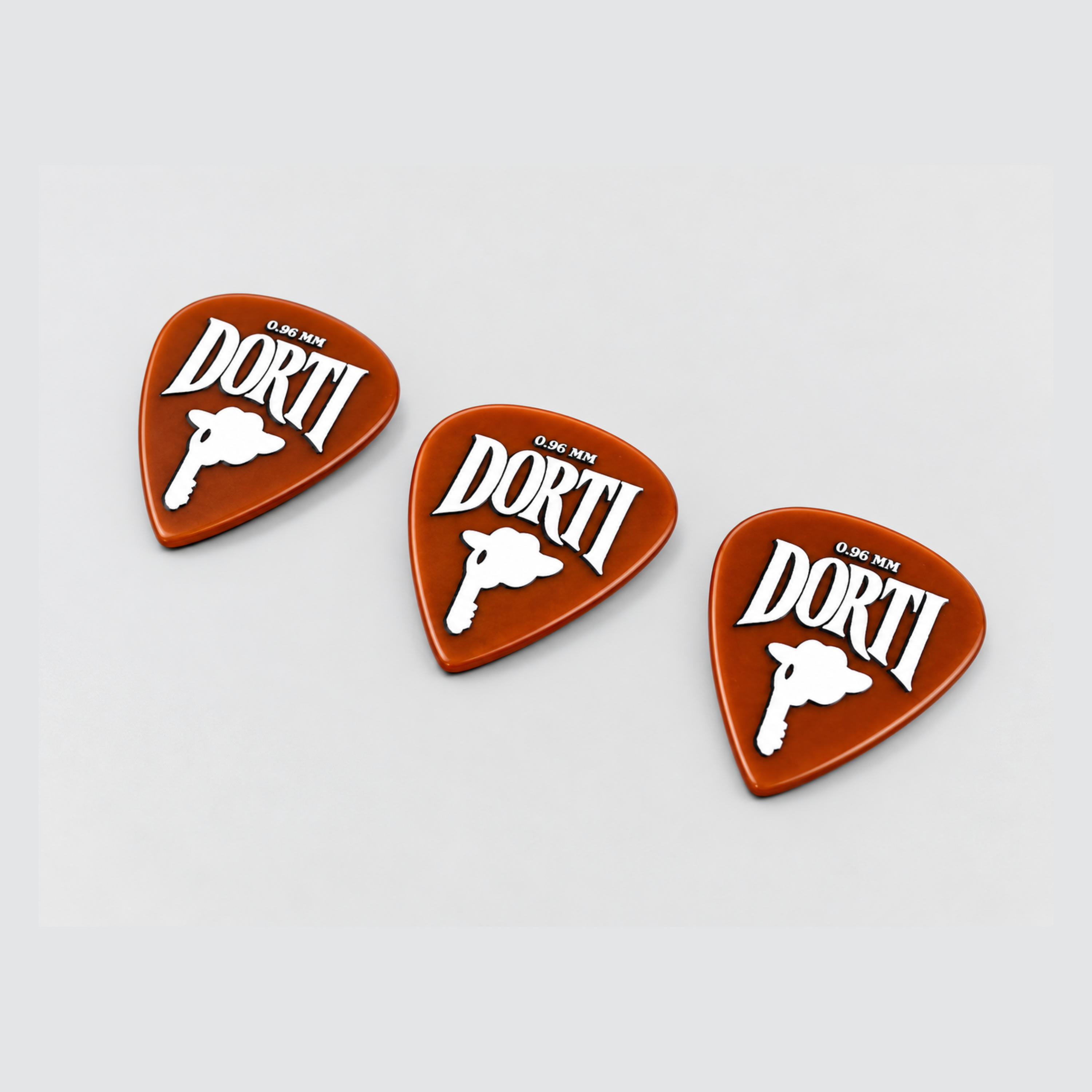 Three DORTI 0.96mm nylon guitar picks at an angle, showing the orange finish