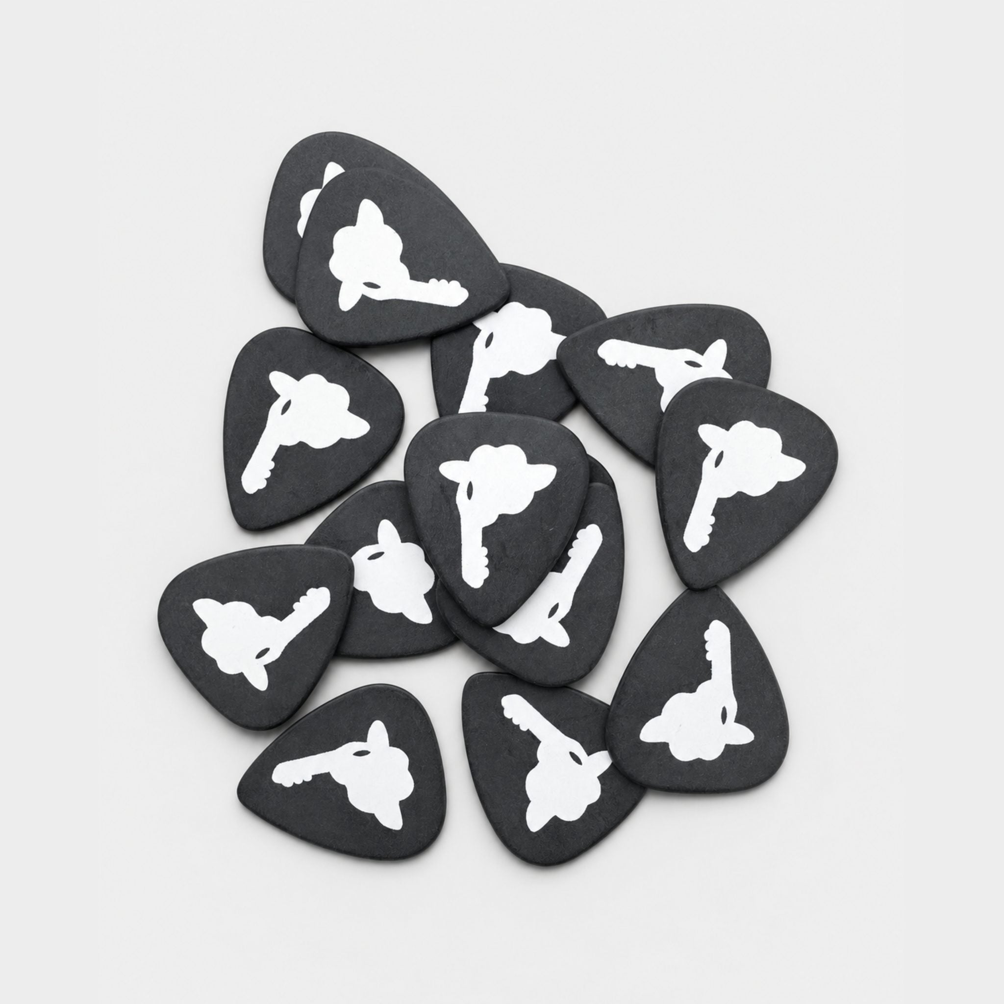 A pile of black DORTI Delrin guitar picks with the Jimi Skull logo