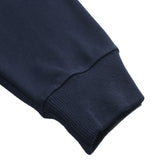 Close-up of a navy blue DORTI sweater sleeve on a white background
