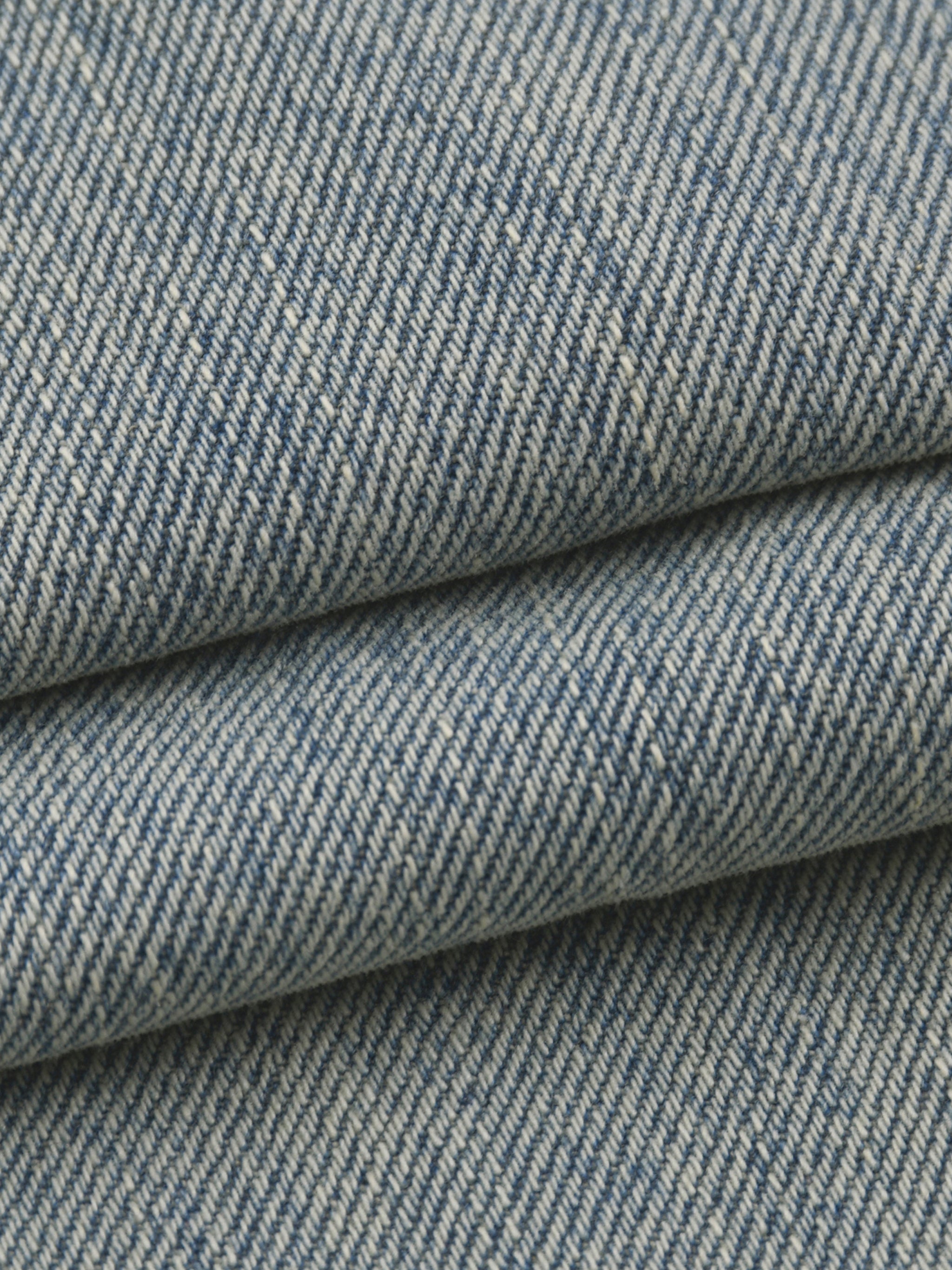 Close-up of the DORTI blue denim jacket with a subtle pattern
