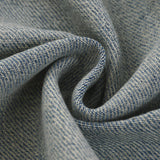 Close-up of textured DORTI blue denim jacket with a subtle pattern