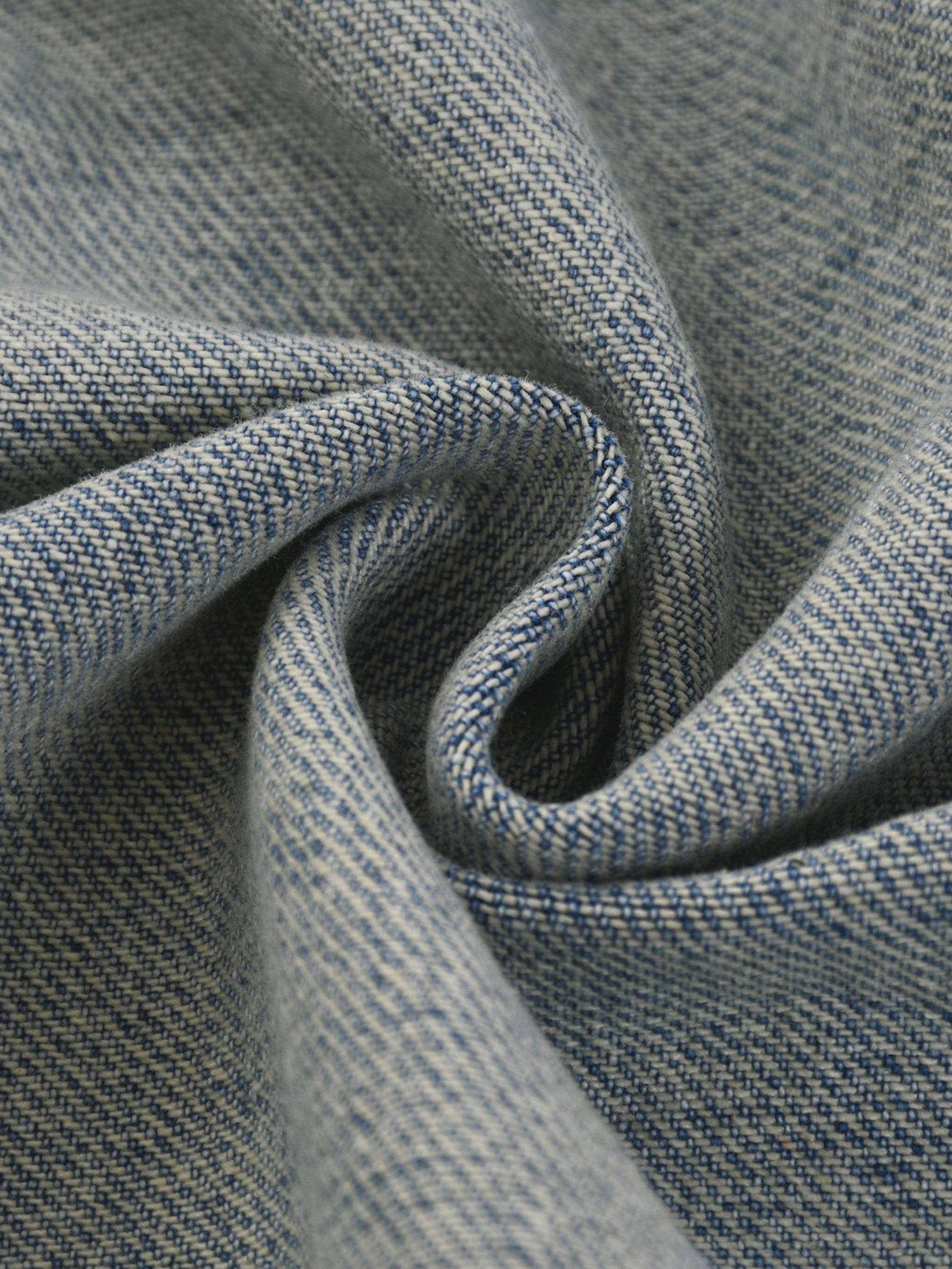 Close-up of textured DORTI blue denim jacket with a subtle pattern